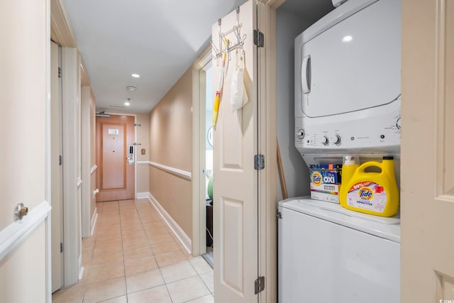 washroom featuring recessed lighting, light tile patterned floors, stacked washer / drying machine, baseboards, and laundry area