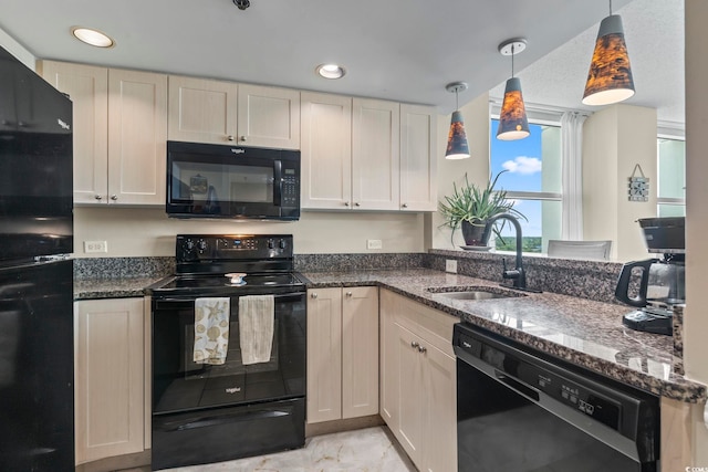 kitchen featuring dark stone counters, recessed lighting, a sink, hanging light fixtures, and black appliances