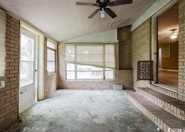 interior space with brick wall, plenty of natural light, and lofted ceiling