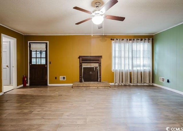 unfurnished living room with crown molding, a ceiling fan, a textured ceiling, and wood finished floors