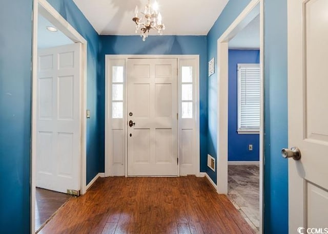 entryway featuring baseboards, an inviting chandelier, and hardwood / wood-style flooring
