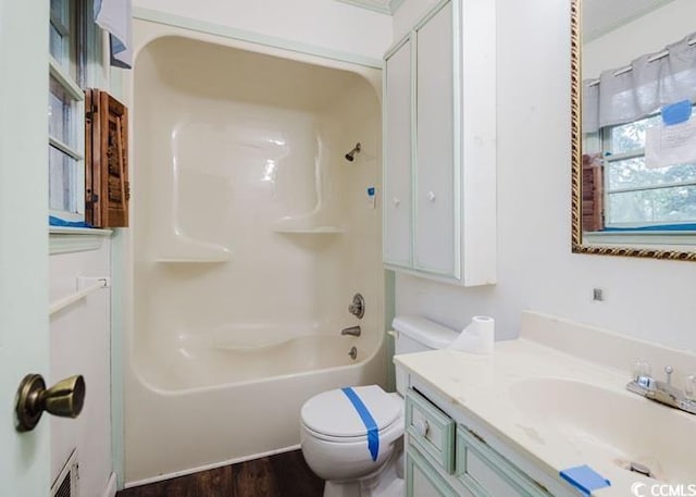 bathroom with vanity, toilet, wood finished floors, and tub / shower combination