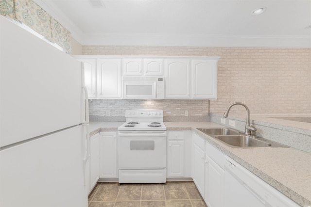 kitchen featuring white appliances, light countertops, crown molding, and a sink