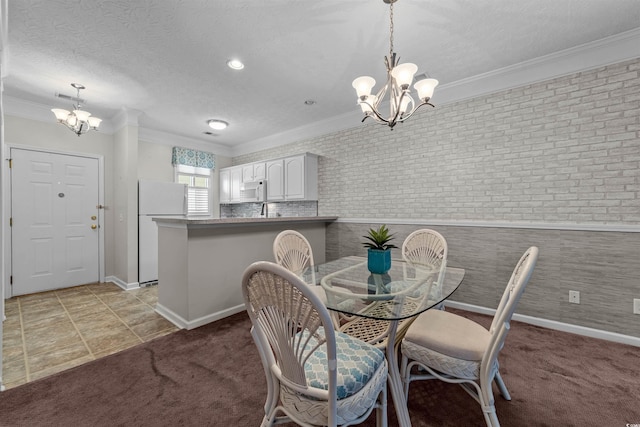 dining room with an inviting chandelier, ornamental molding, light colored carpet, and a textured ceiling