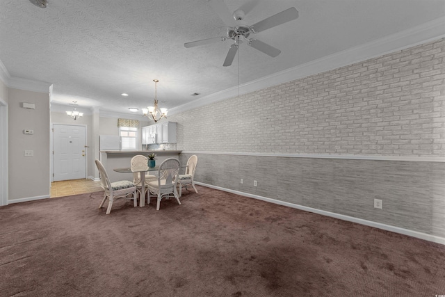 dining space featuring ornamental molding, ceiling fan with notable chandelier, a textured ceiling, carpet flooring, and baseboards