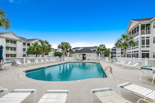 pool featuring a patio area, fence, and a residential view