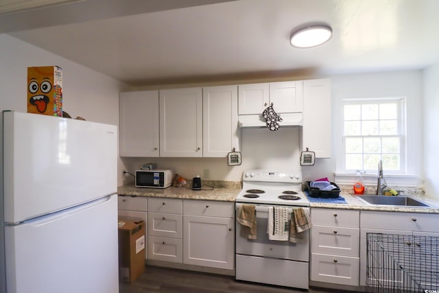 kitchen featuring dark wood finished floors, white appliances, and a sink