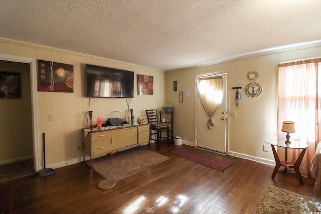 foyer with dark wood-type flooring, baseboards, and a textured ceiling