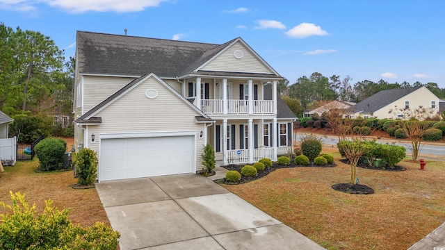 view of front of property with a porch, a balcony, a garage, and a front lawn