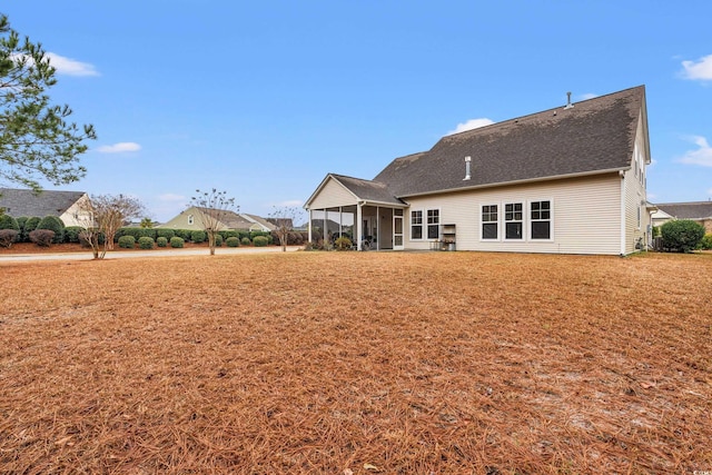 rear view of house with a yard and a sunroom