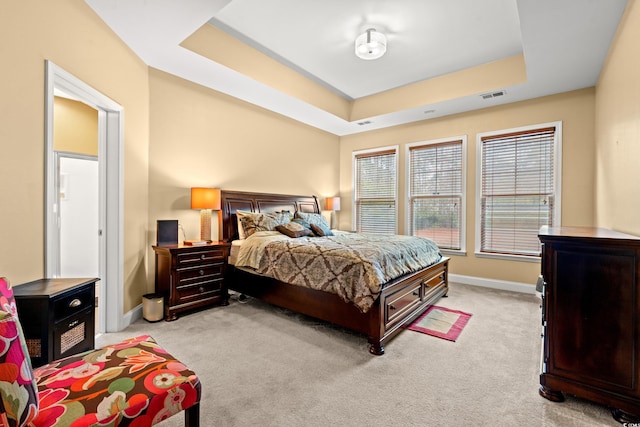 carpeted bedroom with a tray ceiling