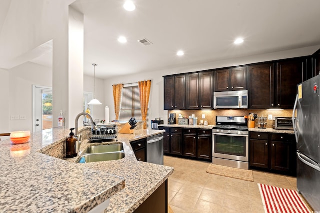 kitchen featuring sink, backsplash, dark brown cabinets, stainless steel appliances, and decorative light fixtures