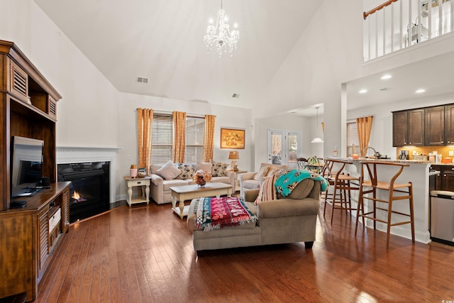 3000 Chesterwood Ct, Myrtle Beach, SC 29579 - living room with high vaulted ceiling, dark wood-type flooring, a chandelier, and a warm lit fireplace