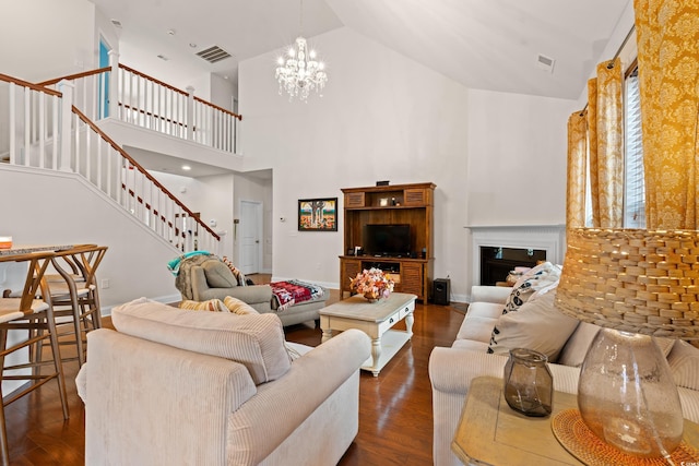 living room with dark hardwood / wood-style floors, high vaulted ceiling, and a notable chandelier