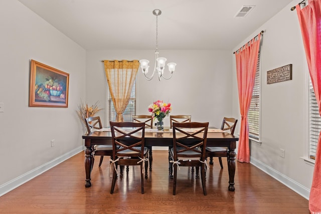 dining space featuring hardwood / wood-style floors, a notable chandelier, and plenty of natural light