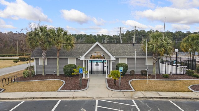 view of property featuring uncovered parking and fence