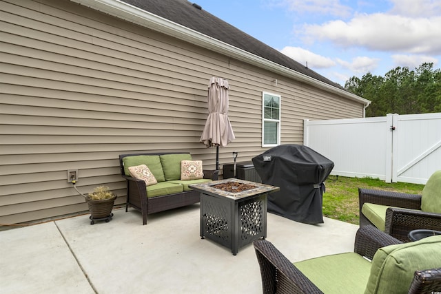 view of patio featuring a gate, an outdoor living space with a fire pit, fence, and area for grilling