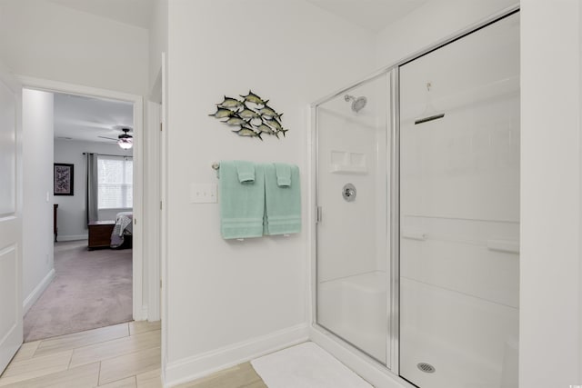 ensuite bathroom with a stall shower, connected bathroom, baseboards, and ceiling fan