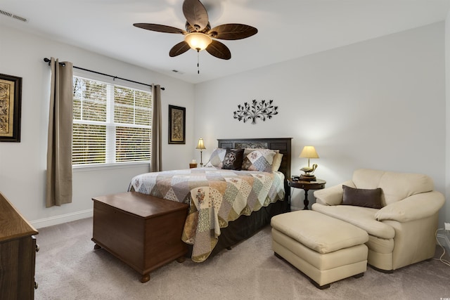 bedroom featuring light colored carpet, visible vents, ceiling fan, and baseboards