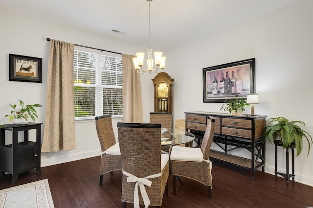 dining area with dark wood-style floors, an inviting chandelier, visible vents, and baseboards