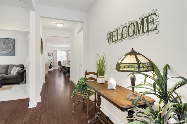 corridor featuring dark wood-style flooring and baseboards