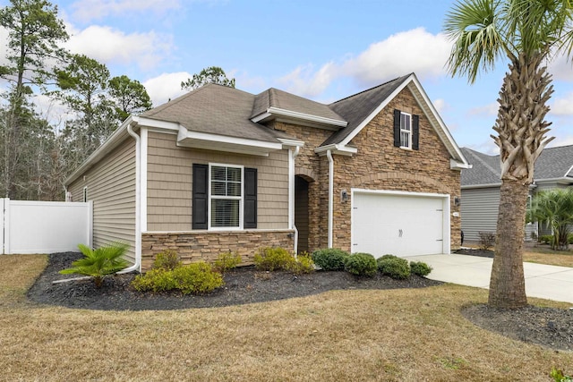 view of front of home featuring stone siding, fence, a front lawn, and concrete driveway