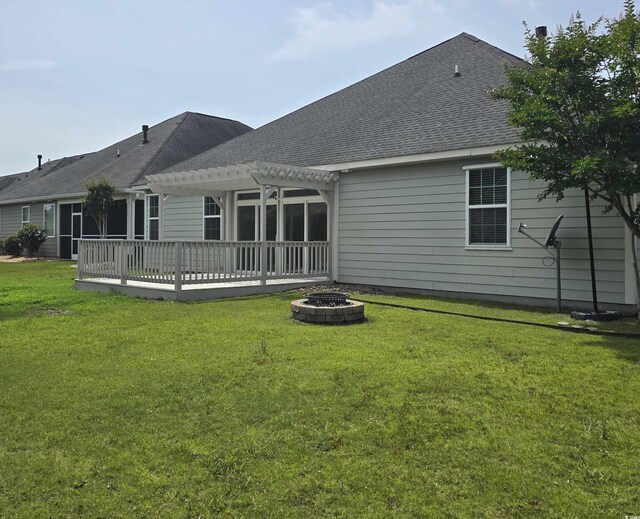 1537 Beaumont Way, Myrtle Beach, SC 29577 - back of property with a pergola, an outdoor fire pit, a lawn, a wooden deck, and a shingled roof