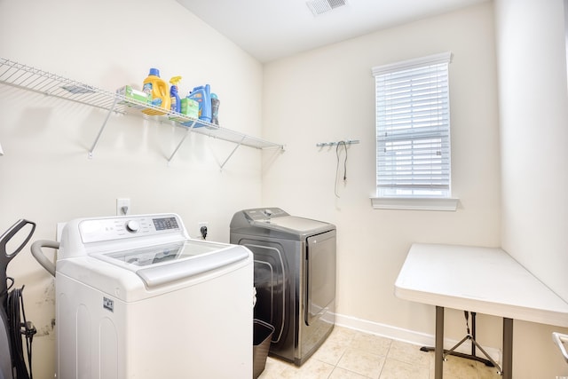 laundry room with separate washer and dryer and light tile patterned flooring