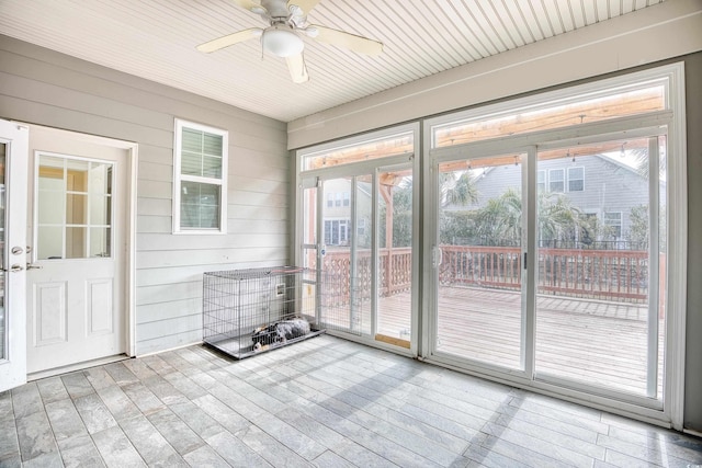 unfurnished sunroom featuring ceiling fan