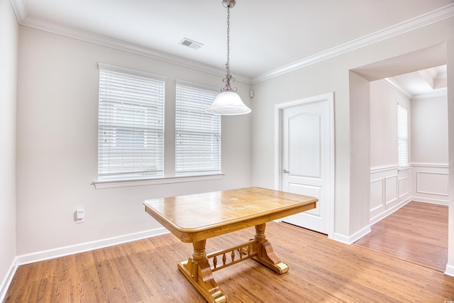 unfurnished dining area featuring ornamental molding and light hardwood / wood-style floors