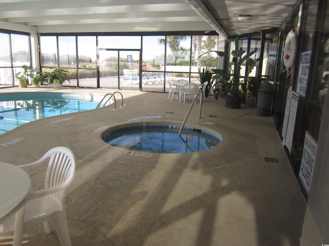 view of swimming pool with glass enclosure, a patio area, and an indoor hot tub