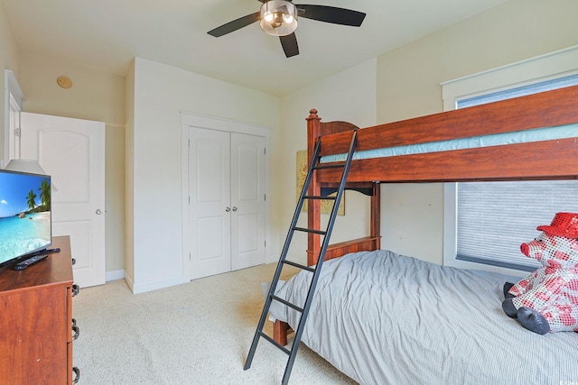 carpeted bedroom with ceiling fan and a closet