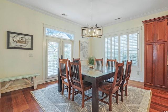 dining space with a notable chandelier, ornamental molding, dark wood-type flooring, and french doors