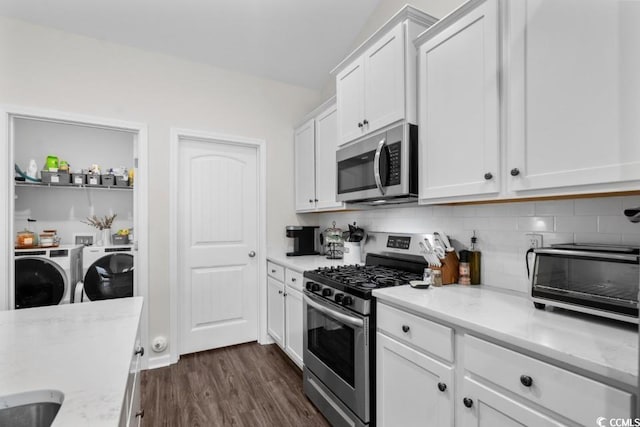 kitchen featuring decorative backsplash, white cabinets, appliances with stainless steel finishes, light stone counters, and independent washer and dryer