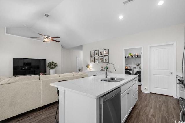 kitchen featuring washing machine and clothes dryer, stainless steel dishwasher, white cabinetry, a sink, and an island with sink