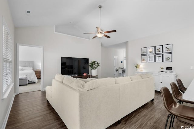 living area with lofted ceiling, dark wood-style flooring, a ceiling fan, and baseboards