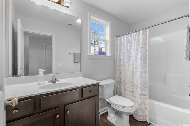 bathroom featuring toilet, wood finished floors, visible vents, vanity, and shower / tub combo with curtain