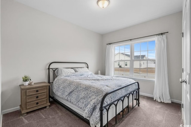 bedroom featuring baseboards and dark carpet