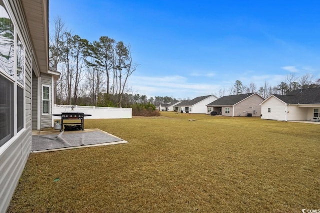 view of yard featuring a patio area, a residential view, and fence