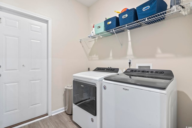 clothes washing area featuring washer and dryer and light hardwood / wood-style floors