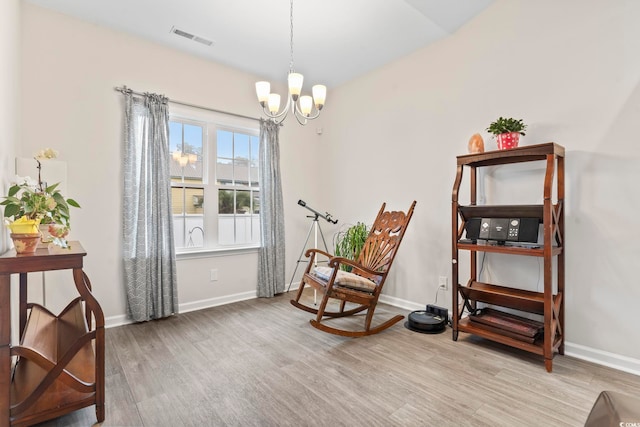 living area with wood-type flooring and a notable chandelier