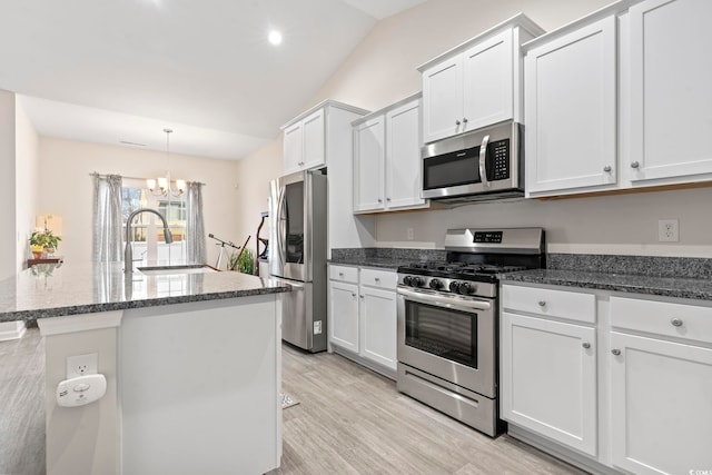 kitchen featuring white cabinetry, appliances with stainless steel finishes, an inviting chandelier, and sink