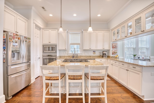 843 Howard Ave, Myrtle Beach, SC 29577 - kitchen with appliances with stainless steel finishes, a peninsula, dark wood-style flooring, white cabinetry, and ornamental molding