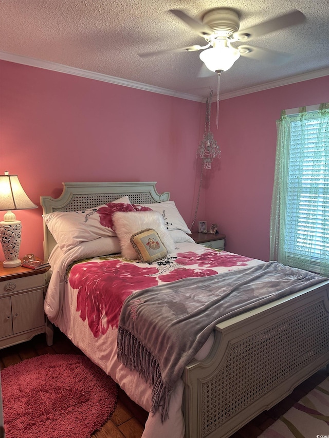 bedroom with ceiling fan, wood-type flooring, ornamental molding, and a textured ceiling