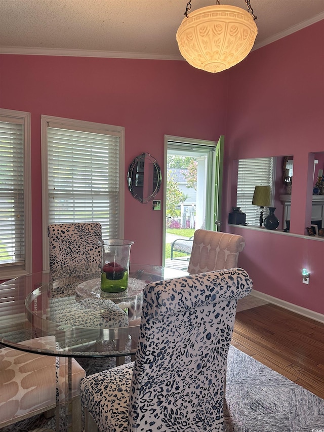 dining space with crown molding, hardwood / wood-style floors, and a textured ceiling