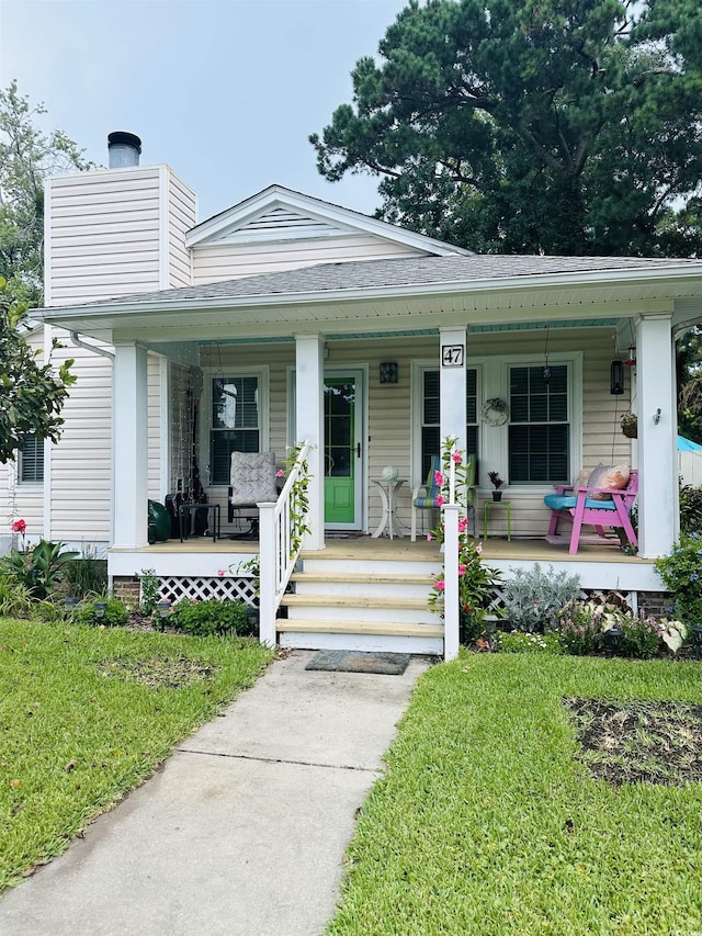 bungalow-style home featuring covered porch and a front lawn