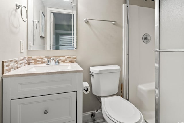 bathroom featuring a shower with door, vanity, toilet, and tasteful backsplash