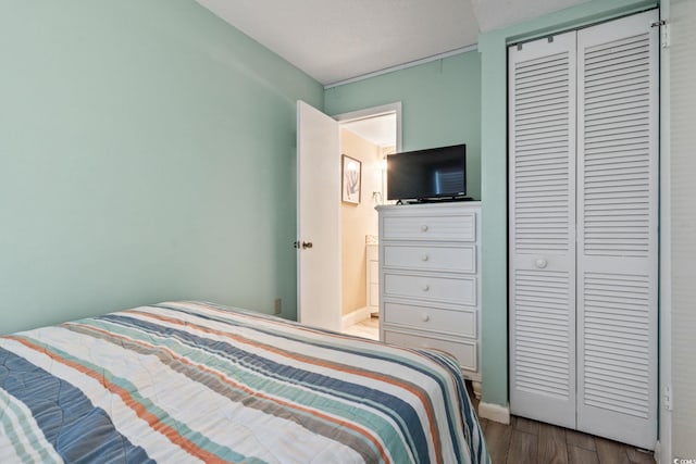 bedroom with a closet, wood-type flooring, and a textured ceiling