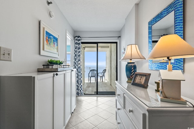 entryway featuring light tile patterned floors and a textured ceiling