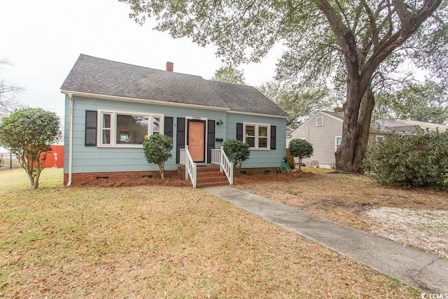 view of front of home with a shingled roof, crawl space, a chimney, and a front lawn